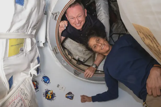 Los astronautas Butch Wilmore y Suni Williams cuando posaban el 13 de junio pasado para un retrato dentro del vestíbulo entre el puerto delantero del módulo Harmony de la Estación Espacial Internacional y la nave espacial Starliner de Boeing