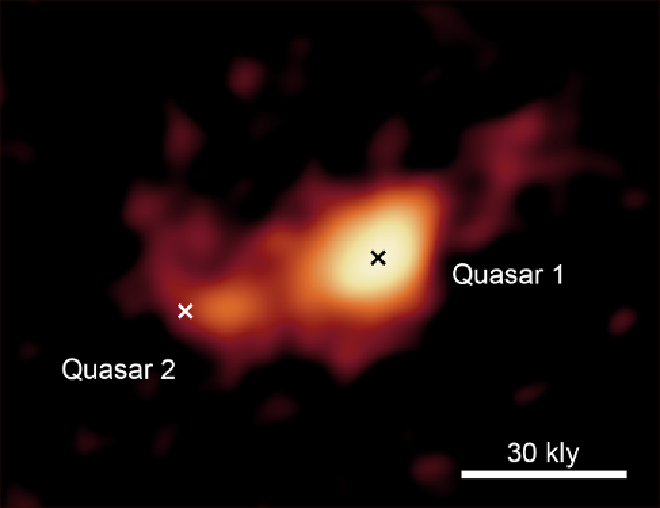 Las galaxias en interacción observadas por el radiotelescopio ALMA en el Amanecer Cósmico. Esta imagen muestra la distribución del gas de carbono ionizado, que refleja la distribución general y el movimiento de la materia interestelar. Se ve claramente que las dos galaxias interactúan y están conectadas por una estructura entre ellas. Las dos cruces de la imagen indican las posiciones de los quásares de baja luminosidad descubiertos por el Telescopio Subaru. Crédito: T.Izumi et al.