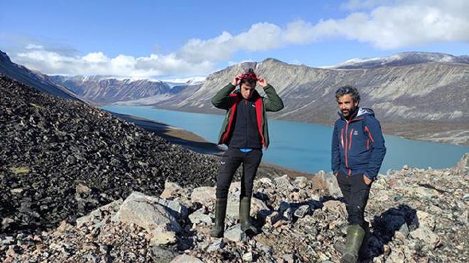 Los profesores e investigadores de la Facultad de Geografía e Historia Josep M.ª Bonsoms y Marc Oliva. Bajo sus pies y a sus espaldas, el resultado del deshielo en Groenlandia. Crédito de la imagen: Patrizia Bruno