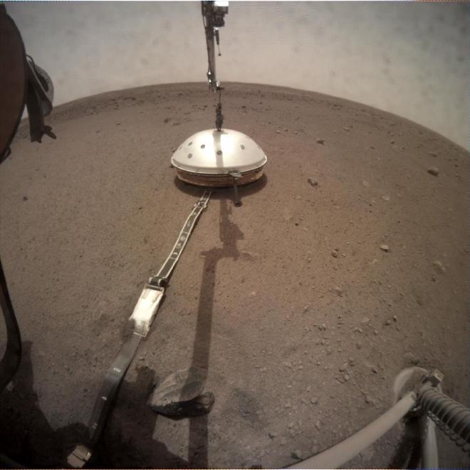 A camera on the robotic arm of NASA’s InSight captured the lander setting down its Wind and Thermal Shield on Feb. 2, 2019. The shield covered InSight’s seismometer, which captured data from more than 1,300 marsquakes over the lander’s four-year mission. Credit: NASA/JPL-Caltech