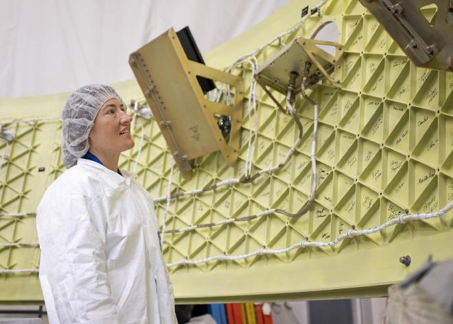 Christina Koch, astronauta de la NASA y especialista de la misión Artemis II, examina el adaptador de la etapa Orión, una estructura en forma de anillo que conecta el cohete SLS de la agencia con la nave espacial Orión. Varios CubeSats se desplegarán desde el adaptador a la órbita alta terrestre durante el vuelo de prueba, entre ellos uno de Argentina. NASA/Charles Beason