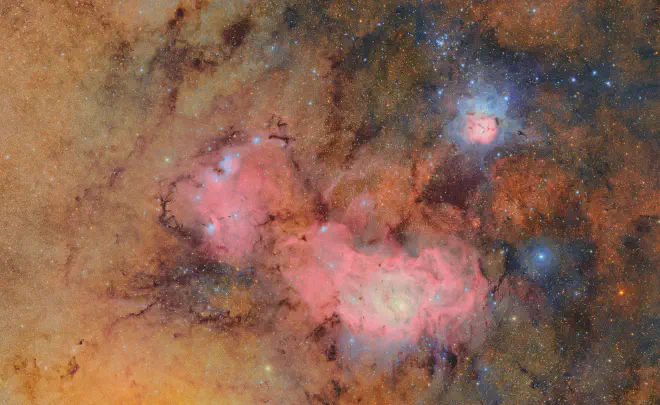 La imagen combina 678 imágenes separadas tomadas por el Observatorio Vera C. Rubin de NSF-DOE en poco más de siete horas de observación. La combinación de muchas imágenes revela detalles sutiles que de otro modo serían tenues o invisibles, como las nubes de gas y polvo que componen la nebulosa Trífida (arriba) y la nebulosa de la Laguna, que se encuentran a varios miles de años luz de la Tierra. Créditos: Observatorio Vera C. Rubin de NSF-DOE