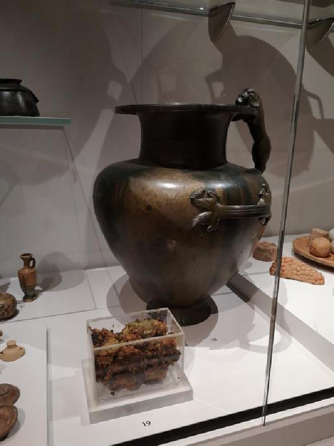 Esta jarra de bronce expuesta en el Museo Ashmolean contenía una sustancia misteriosa (mostrada en primer plano) que muy probablemente sea miel de 2.500 años de antigüedad. Crédito de la imagen: Adaptado del Journal of the American Chemical Society 2025, DOI: 10.1021/jacs.5c04888
