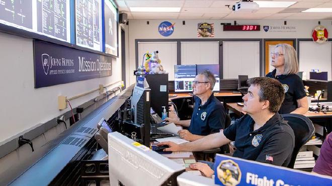 De izquierda a derecha, los controladores de vuelo Mark Lahr y Josh Albers, y la directora de operaciones de la misión, Alice Bowman, supervisan la telemetría que se transmite desde la nave espacial New Horizons de la NASA al centro de operaciones de la misión en el Laboratorio de Física Aplicada Johns Hopkins en Laurel, Maryland, el 24 de junio de 2026. Ahora, a aproximadamente 5900 millones de millas (9500 millones de kilómetros) de la Tierra, New Horizons está lista para comenzar a transmitir datos científicos después de haber sido despertada de su período de hibernación más largo hasta la fecha, de casi un año. Crédito de la imagen: NASA/Johns Hopkins APL/SwRI/Justin Gladden