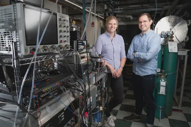 Los hallazgos sugieren que el pireno puede haber sido la fuente de gran parte del carbono de nuestro sistema solar. “Es un sumidero de carbono casi increíble”, dijo Brett McGuire, a la derecha, de pie junto a la autora principal del estudio, Gabi Wenzel. Crédito de la imagen: Bryce Vickmark