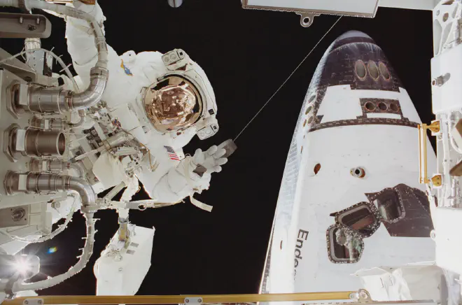 El astronauta John Herrington durante una caminata espacial. En esta fotografía, el astronauta y especialista de la misión STS-113 John B. Herrington, en el centro, durante la tercera caminata espacial de aquella misión. La sección delantera del transbordador espacial Endeavour aparece a derecha. Crédito de la imagen: NASA