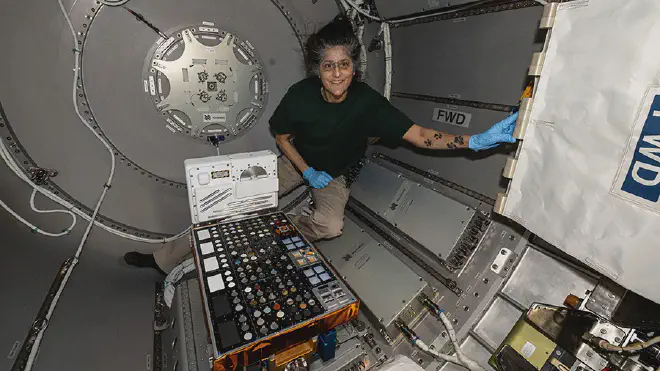 La comandante de la Expedición 72 en la Estación Espacial, Suni Williams, instala el hardware del experimento European Materials Ageing dentro de la escotilla Bishop de Nanoracks, que expondrá una variedad de materiales al vacío del espacio durante aproximadamente un año.