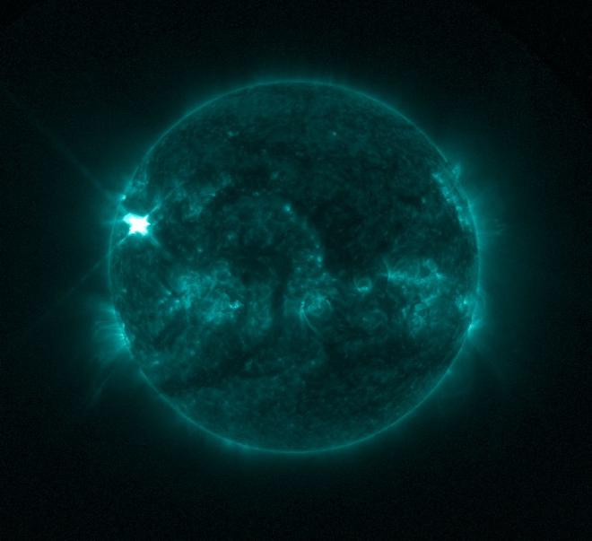 El Generador de Imágenes Solares Ultravioleta de la Administración Nacional Oceánica y Atmosférica de Estados Unidos, capturó esta imagen de una llamarada solar, vista como el destello brillante en la parte superior izquierda, el 3 de enero de 2025. La imagen muestra un subconjunto de luz ultravioleta extrema que resalta el material extremadamente caliente en las llamaradas y que está coloreado en verde. Crédito: NOAA